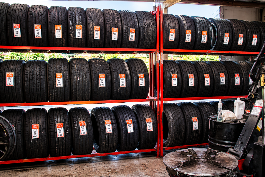 Large selection of quality used tires on red racks at Humble Tire & Automotive — Humble, TX